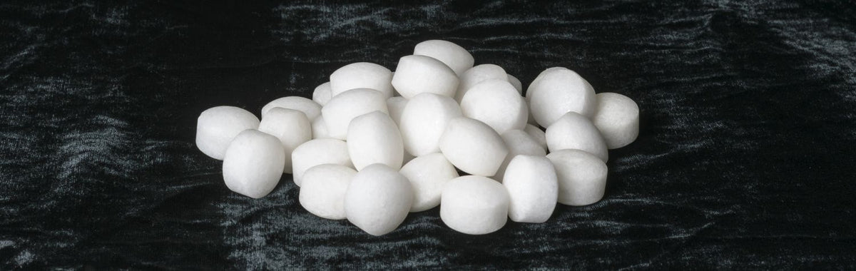 Pile of white mothballs on a dark surface