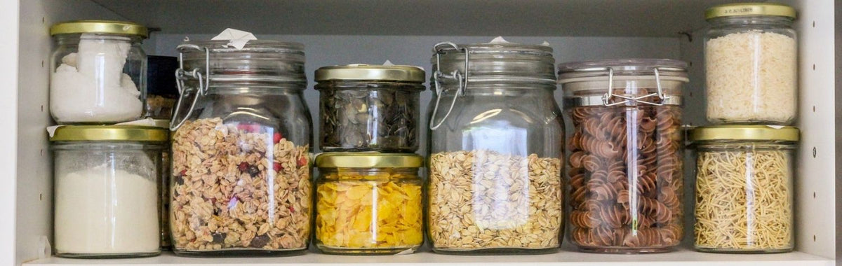 Pantry shelf of sealed glass jars that keep dry goods safe from pantry bugs