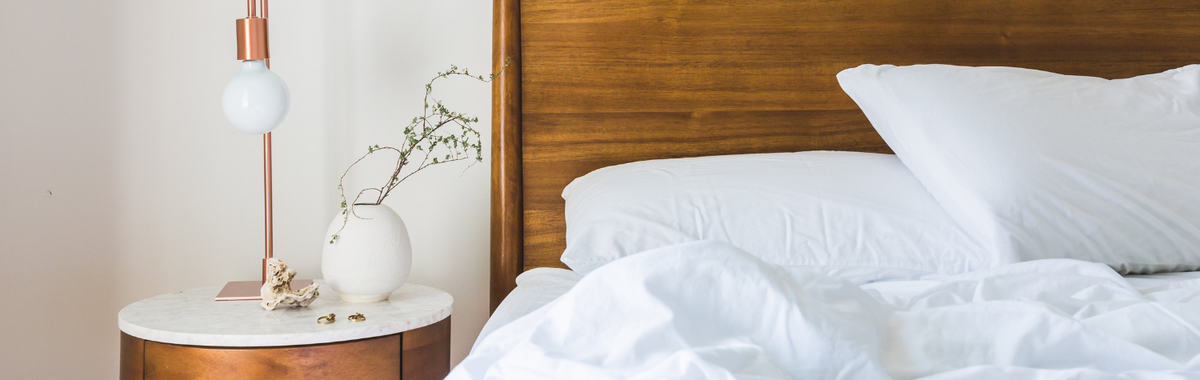 Neatly made bed with white pillows, where you might wonder what bit you in your sleep