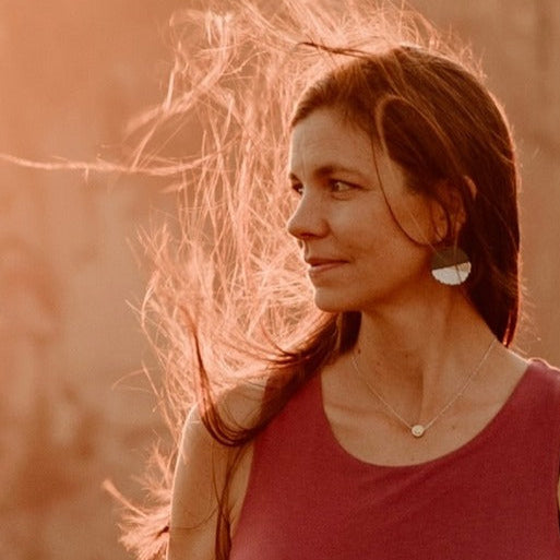 Julie standing outside with red shirt and blurred background