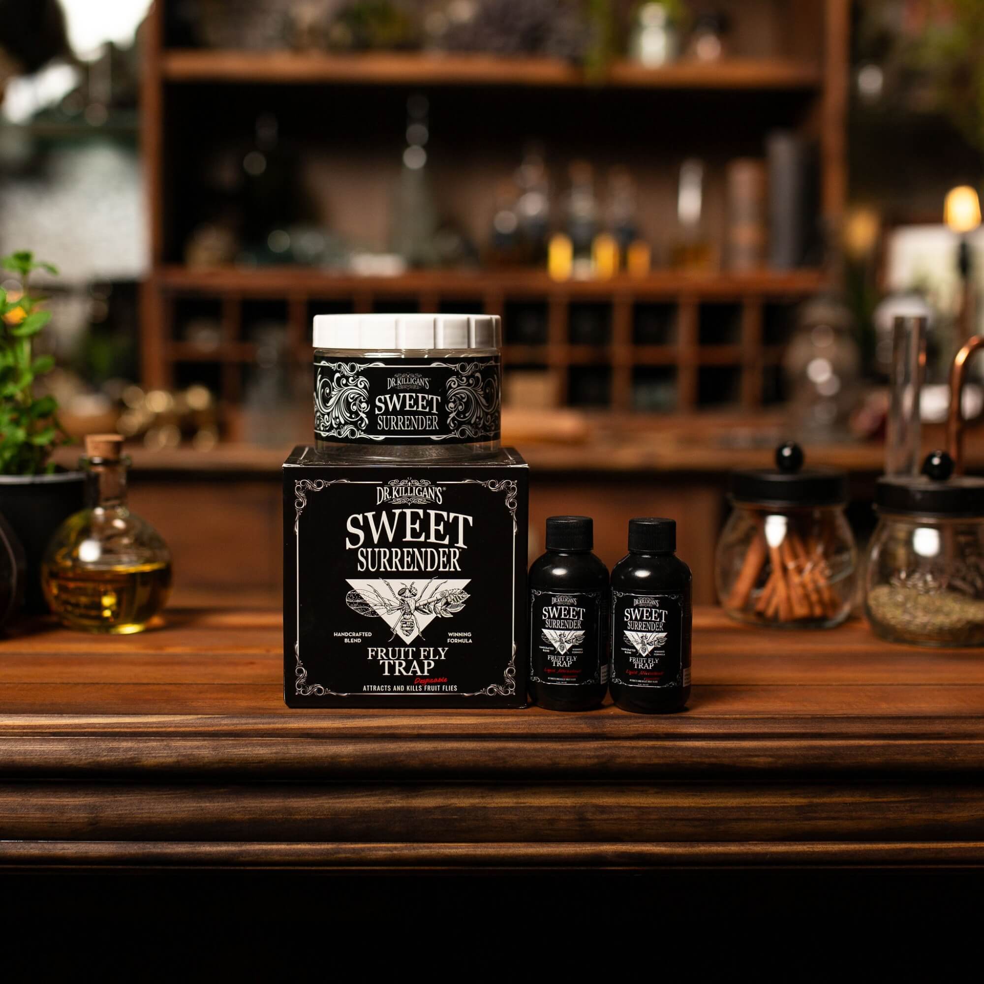 Sweet Surrender Fruit Fly Trap product packaging on a wooden surface with a blurred background