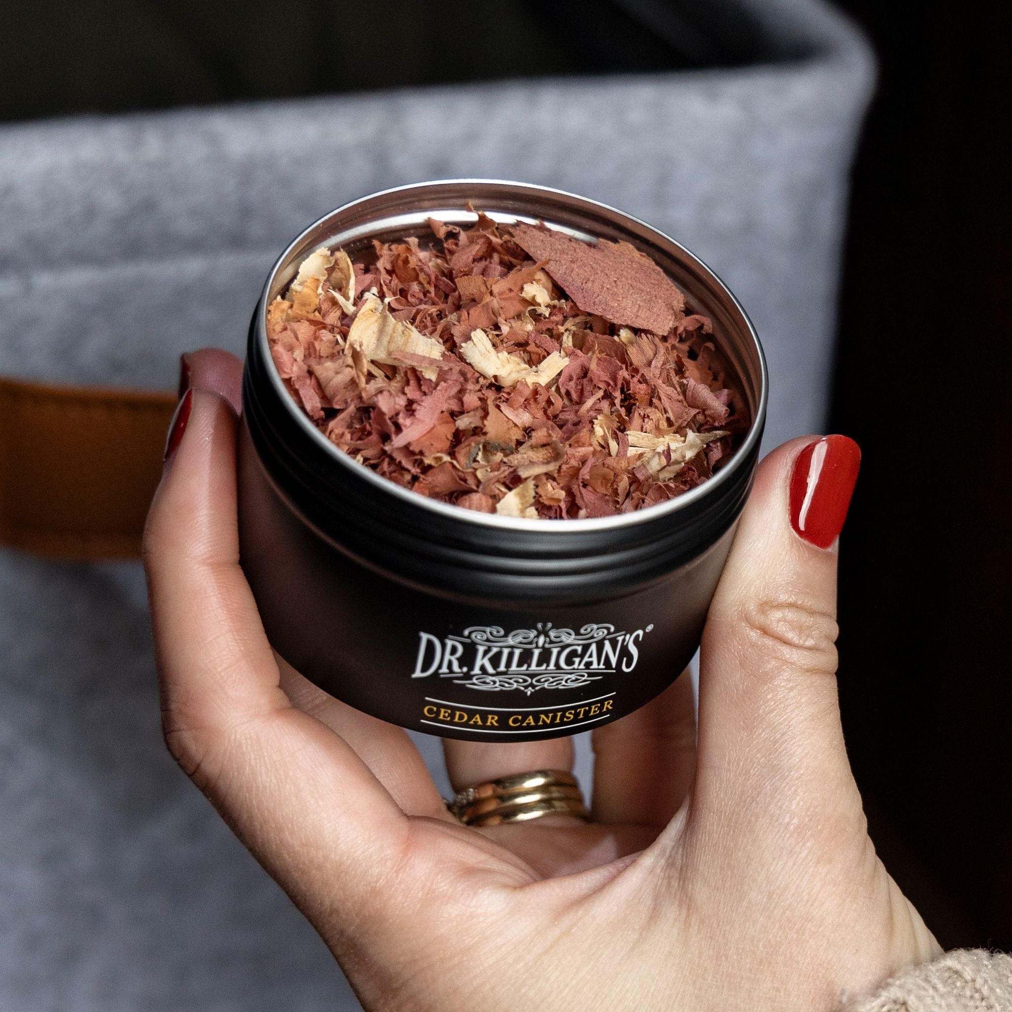 Person holding cedar canister with blurred background